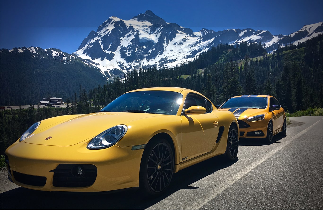 Cover Photo of two shiny yellow sports cars against a majestic snow-capped mountainview