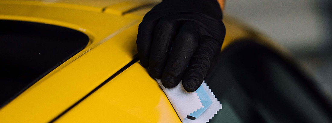 A RestorFX Technician protecting the painted surface of a brilliant yellow sports car with ClearFX Exterior product