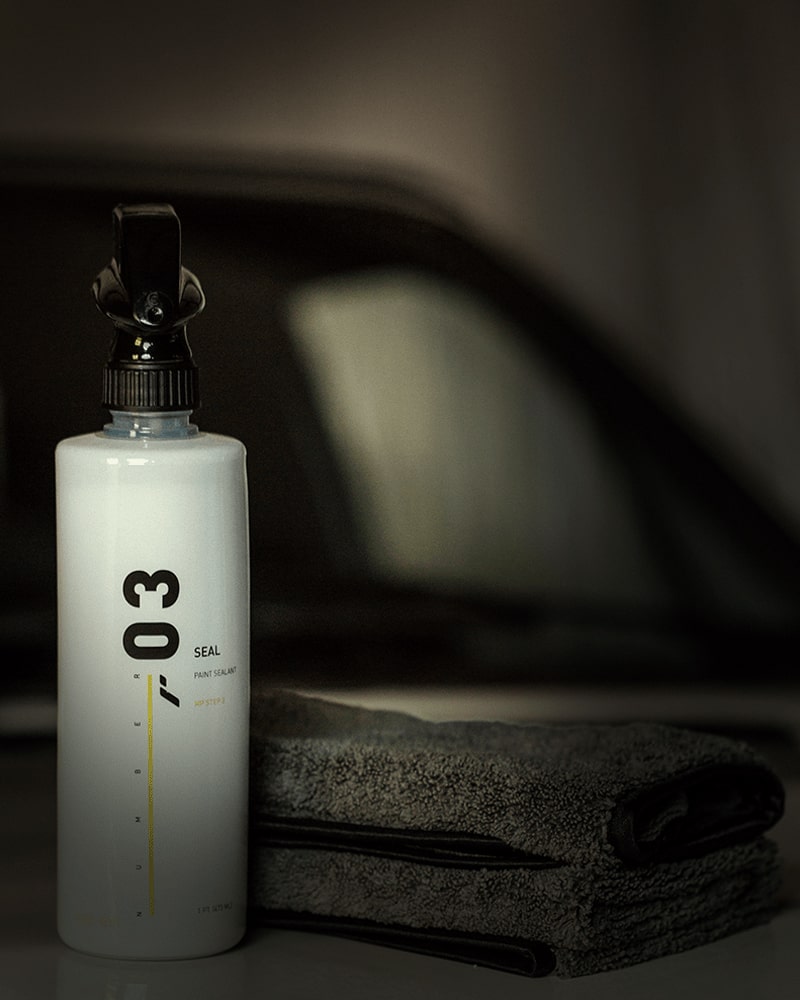 RestorFX Number 03 Seal product bottle and 16 Numbers Microfiber with a car in the background